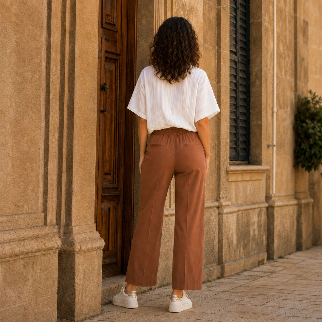 Die Adele Michael Hose mit der weissen Rüschenbluse Daisy von 0039 Italy und dazu Lemargo Sneaker in Offwhite in den Strassen in Italien von hinten.