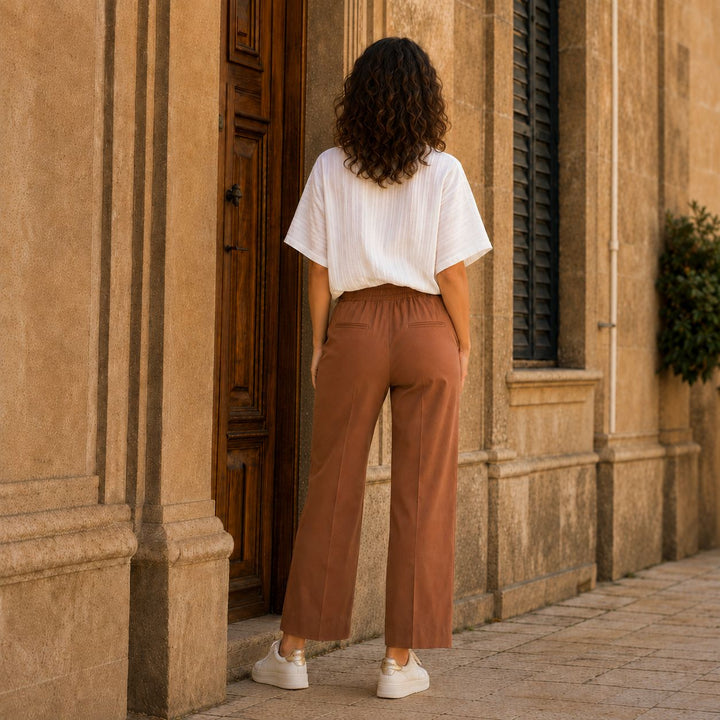 Die Adele Michael Hose mit der weissen Rüschenbluse Daisy von 0039 Italy und dazu Lemargo Sneaker in Offwhite in den Strassen in Italien von hinten.