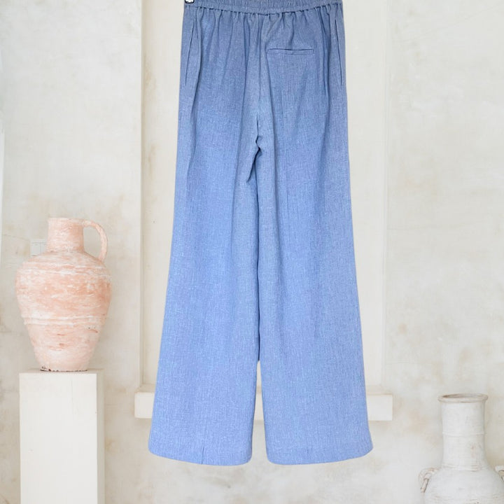 Adele Pants Peter in Jeans-Blau aus Leinen-Viskose-Mix, Rückansicht auf Holzbügel.