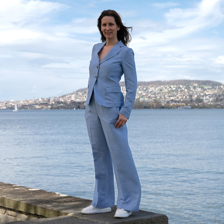 Adele Pants Peter in Jeans-Blau aus leichtem Leinen-Viskose-Mix, seitlich getragen am Zürichsee, kombiniert mit dem passenden Adele Blazer Lola.