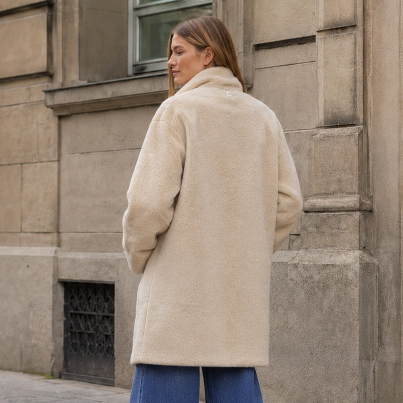 Rückansicht des APPARIS Blair Coat in Latte kombiniert mit weiter blauer Jeans