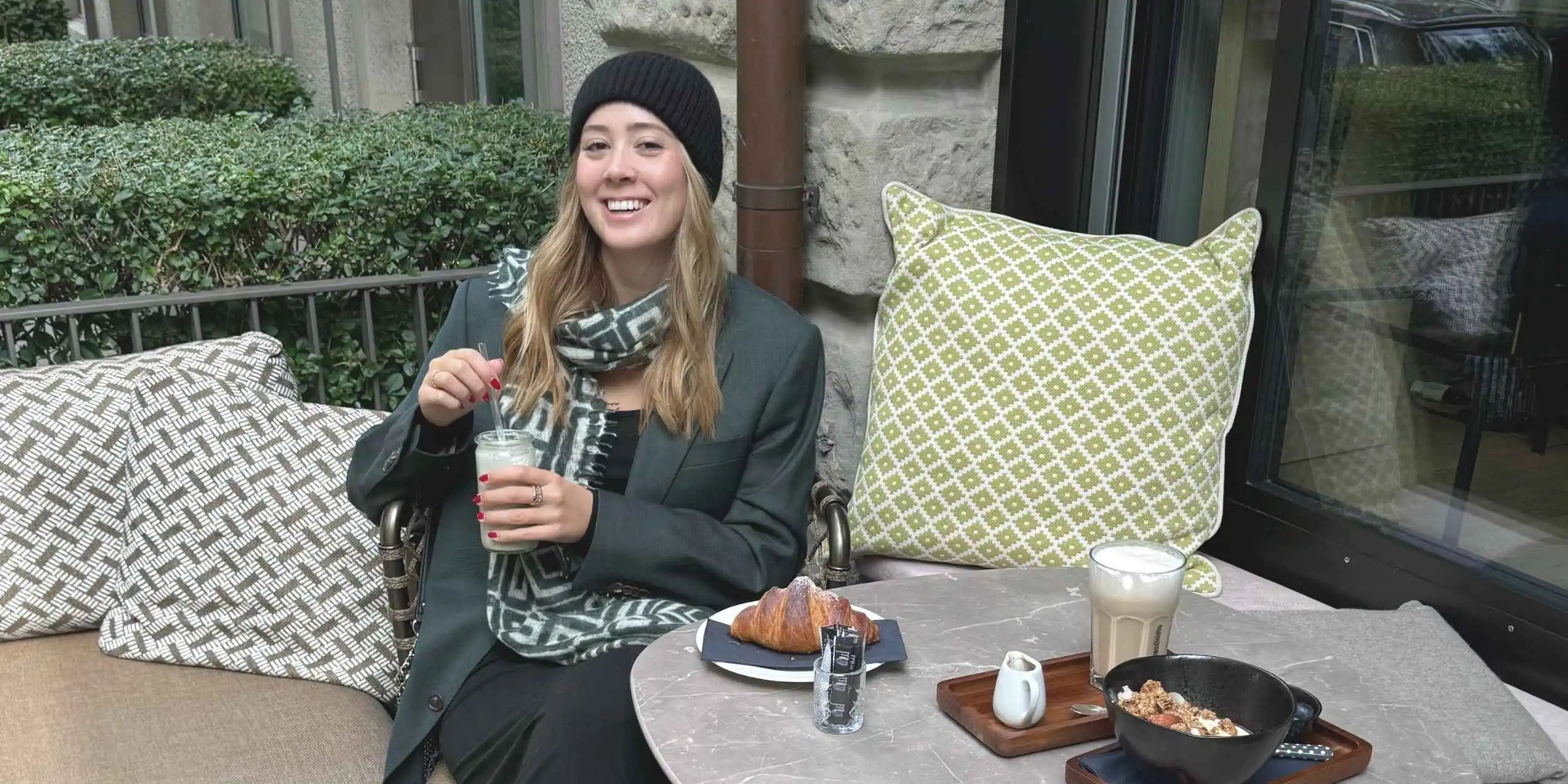 Luana von NoAna Beauty beim Frühstück sitzend in Kaffee in Zürich mit Cashimar Mütze und Leomax Schal