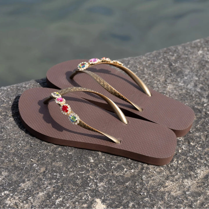 Chanclas by Simone Herrera Antonia in Braun mit multicolor Strass, seitliche Outdoor-Aufnahme der Flip Flops.