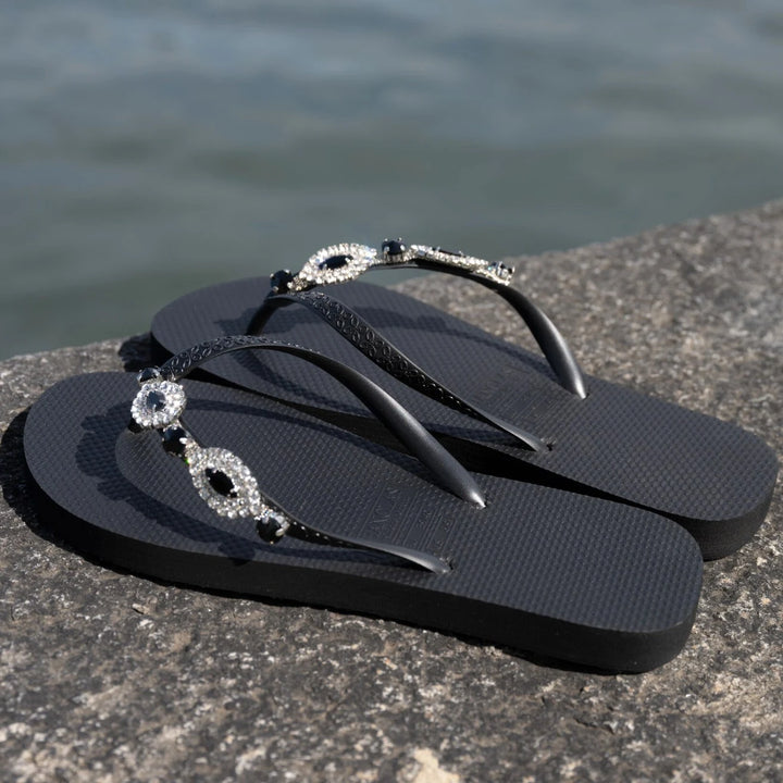 Chanclas by Simone Herrera Carlina in Schwarz mit Strassdetails, seitliche Outdoor-Aufnahme der Flip Flops.