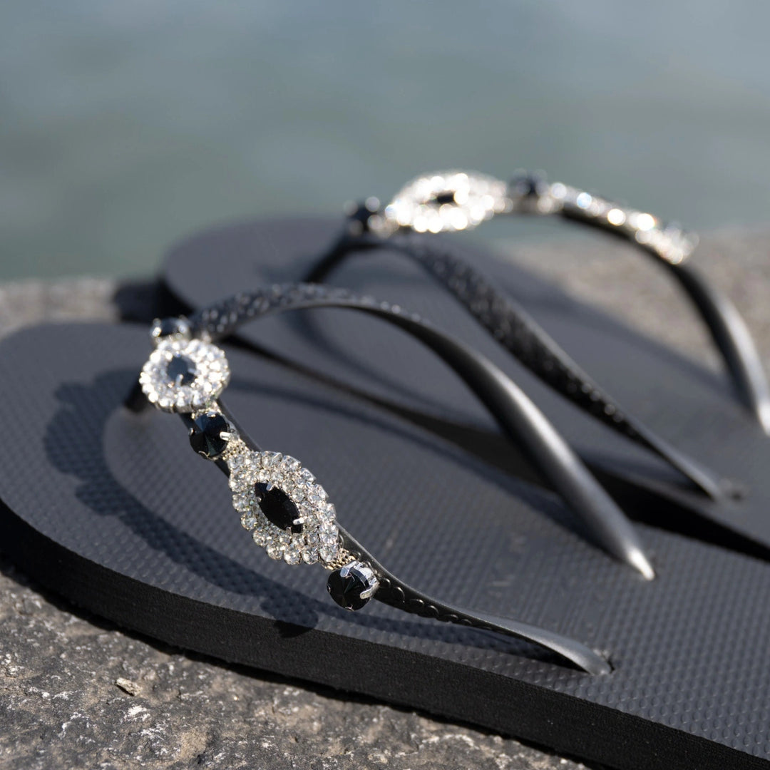 Chanclas by Simone Herrera Carlina in Schwarz, Outdoor-Aufnahme der Flip Flops am Wasser.