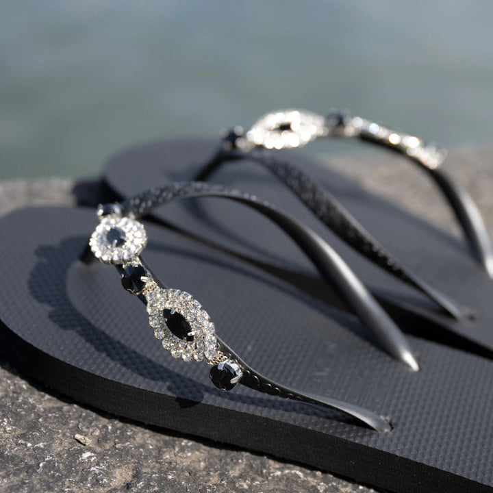 Chanclas by Simone Herrera Carlina in Schwarz, Outdoor-Aufnahme der Flip Flops am Wasser.