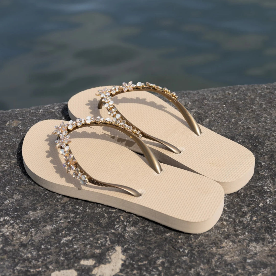 Chanclas by Simone Herrera Valerie in Beige mit Full-Diamond-Straps, draussen am Wasser auf Stein fotografiert, Flip Flops.