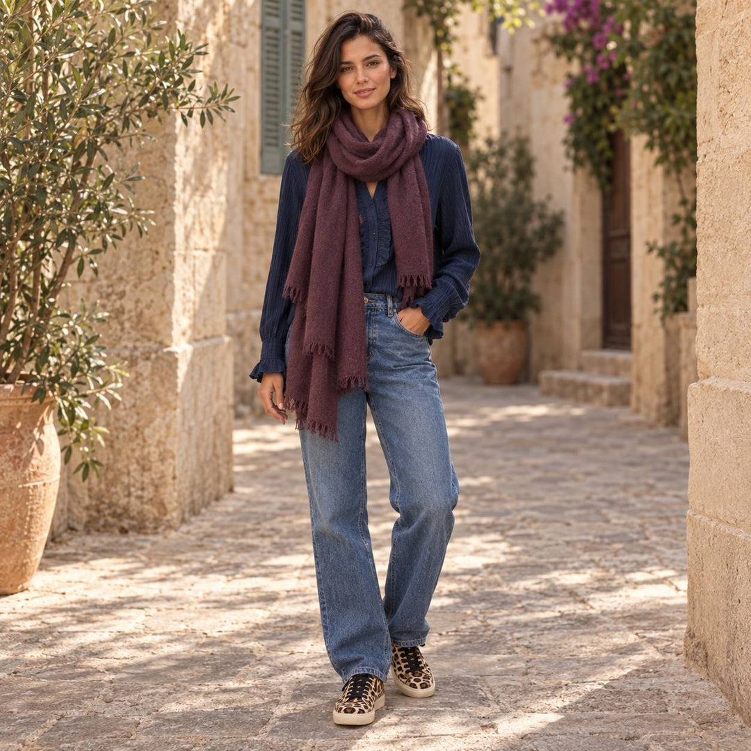 Model trägt Cute Stuff Cashmere Schal Feli in Dark Brown-Bordeaux mit dunkler Emotions Frill-Bluse, Jeans und Dianetti Leo Sneakern