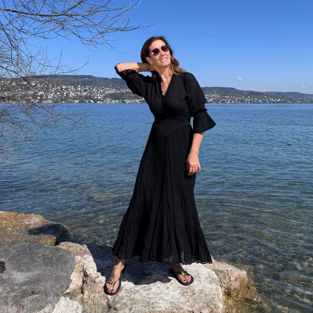 D’ARTEMIDE Eleni Dress in black aus 100% Baumwolle, langes Sommerkleid mit Fledermausärmeln, frontal getragen am See