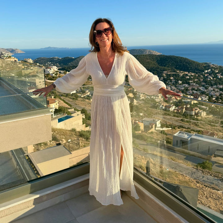 D'Artemide Nephele Dress Ivory auf Dachterrasse mit Meerblick und Glasgeländer