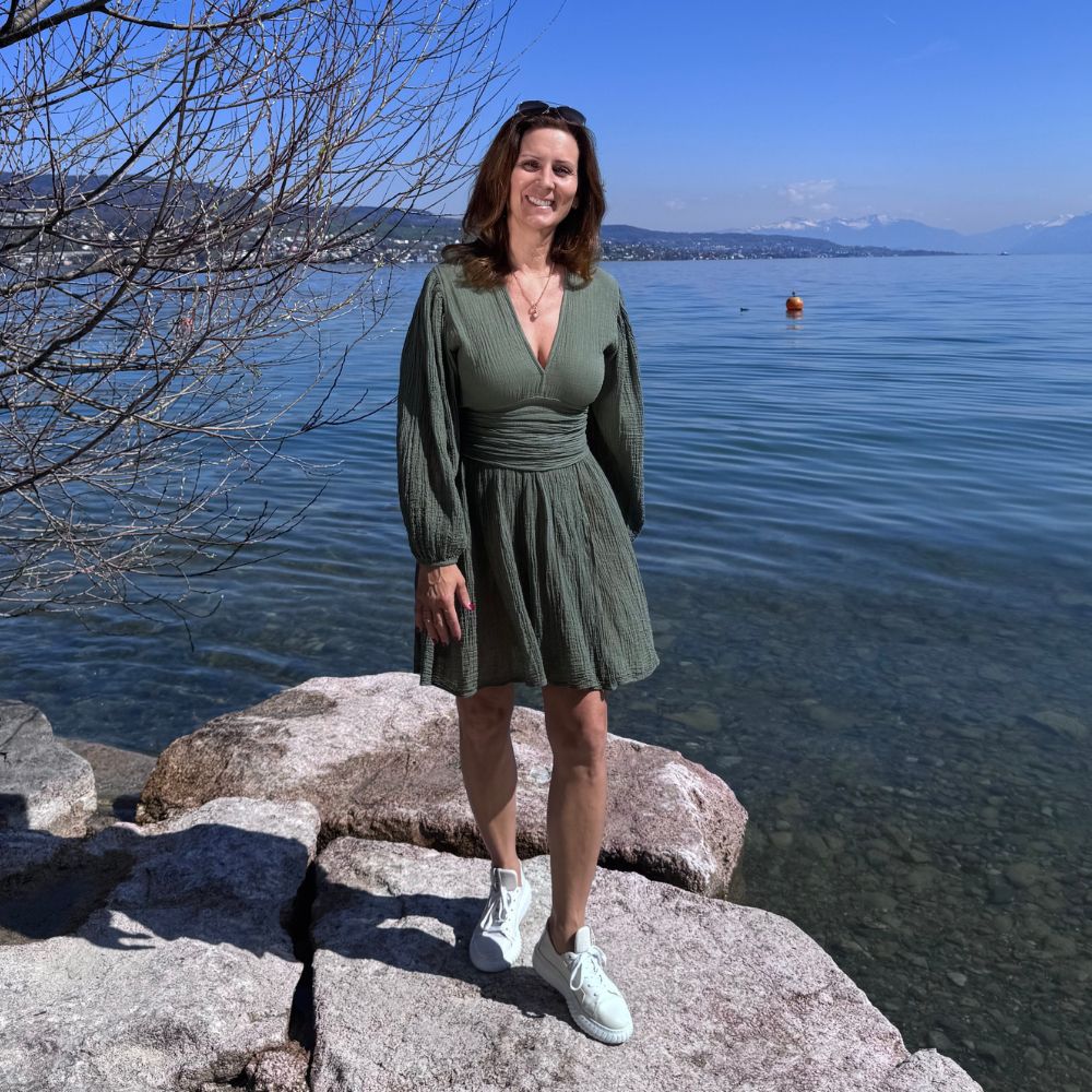 D’ARTEMIDE Nephele Dress Mini in khaki aus 100 % Baumwolle, kurzes Sommerkleid mit V-Ausschnitt, frontal getragen am See