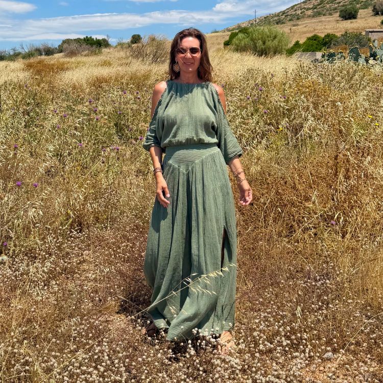 Janine im khakifarbenen D'Artemide Sappho Dress in mediterraner Landschaft mit fliessendem Schnitt.