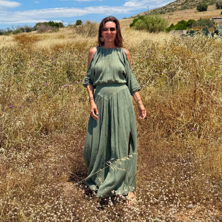 Janine im khakifarbenen D'Artemide Sappho Dress in mediterraner Landschaft mit fliessendem Schnitt.
