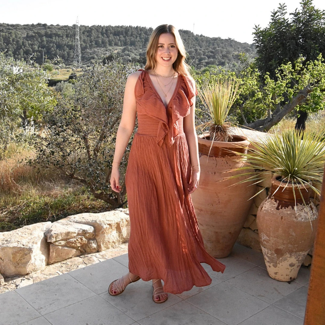 D’ARTEMIDE Serene Dress in sienna aus 100 % Baumwolle, luftiges Sommerkleid mit V-Ausschnitt, frontal getragen in mediterraner Umgebung
