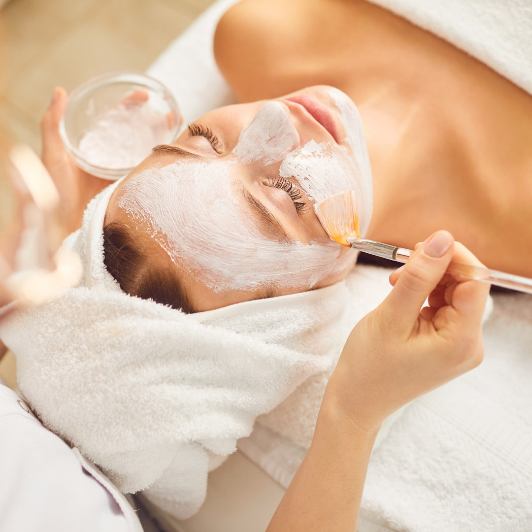 Gesichtsbehandlung Deep Clean Facial, reinigende Gesichtsmaske wird mit Pinsel aufgetragen im Kosmetikstudio