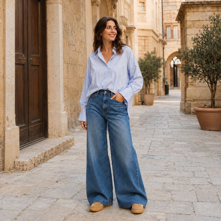 Emotions Iceblue Bluse mit Wide Leg Jeans kombiniert mit den Voile Blanche  Sneakern Mind 02 W auf einer Strasse.