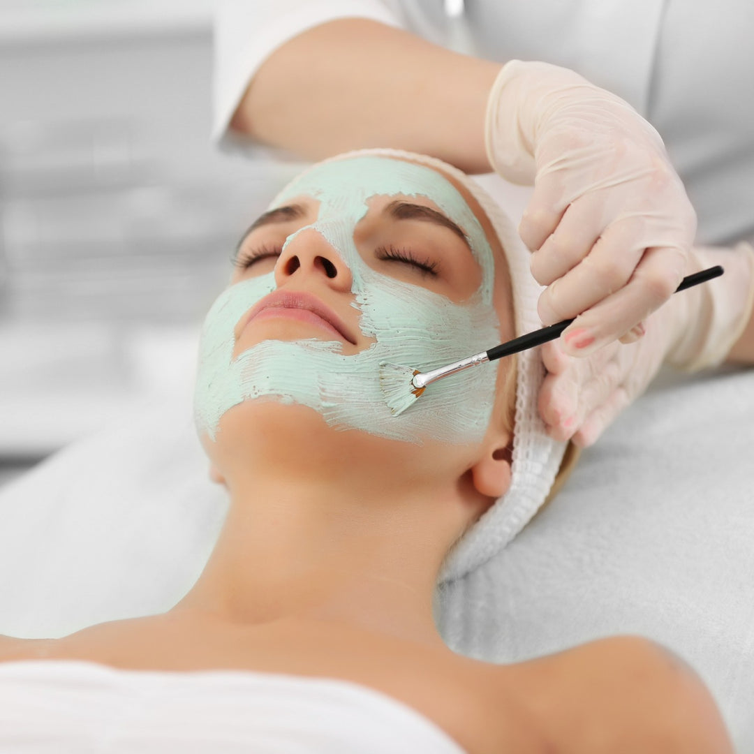 Frau erhält eine Gesichtsmaske während einer professionellen Gesichtsbehandlung.