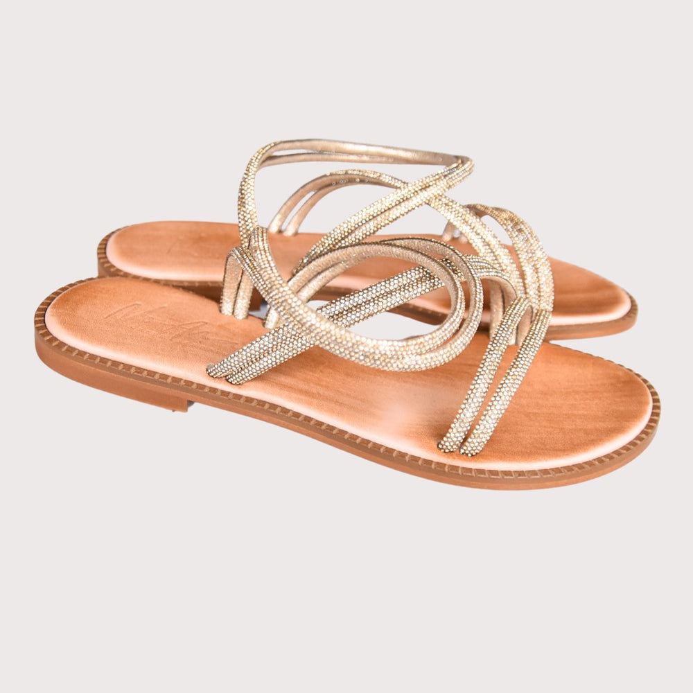 NoAna Greek Sandals Naomi in Gold aus Leder, schräg fotografiert im Studio mit geflochtenen Riemen