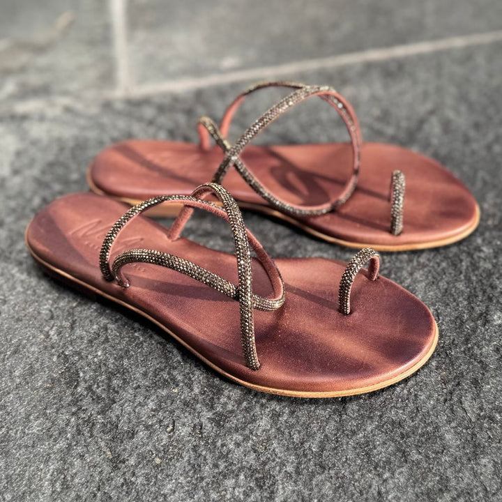 NoAna Greek Sandals Tracy in bronze aus Leder mit Strassriemen, flache Sandalen schräg von vorne