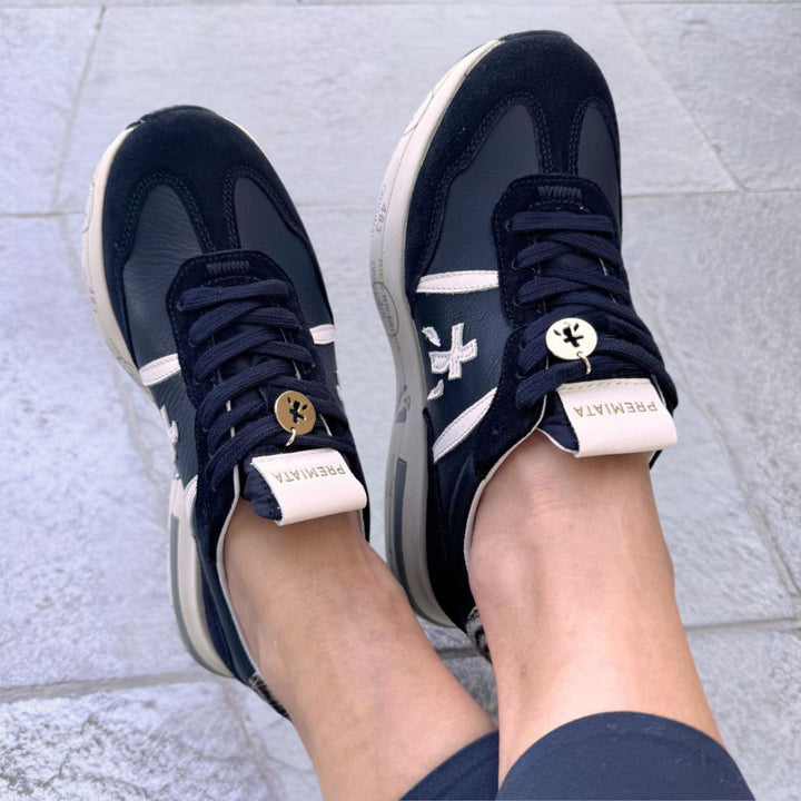 Premiata Cassie Damen-Sneaker in Schwarz mit weissen Applikationen und Zebra-Detail an der Ferse, getragen
