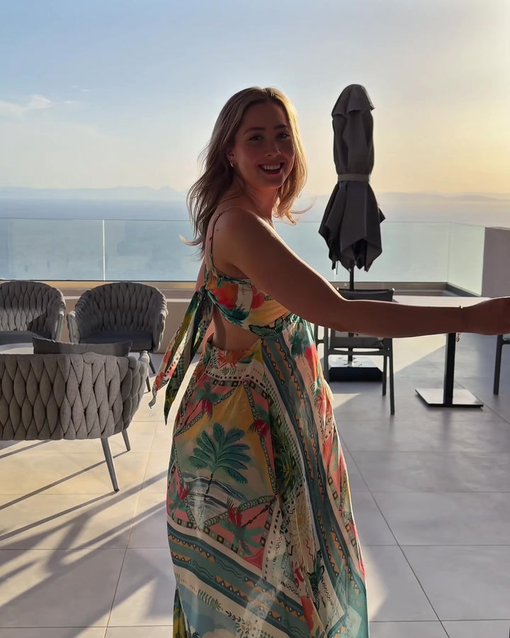 Miss June Long Dress Britney Blue Multi fliessendes Sommerkleid mit Print auf Terrasse mit Meerblick