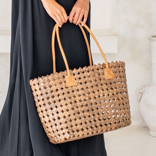 Salty Skin Beach Bag aus geflochtenen Palmblättern mit Lederhenkeln, handgemachte Strandtasche im natürlichen Studio-Setting