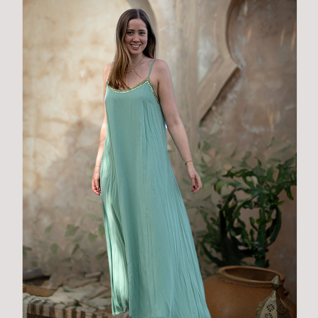 Salty Skin Longdress Women sage aus 100% Viscose, langes Trägerkleid mit goldfarbenem Paillettenabschluss im Outdoor-Setting