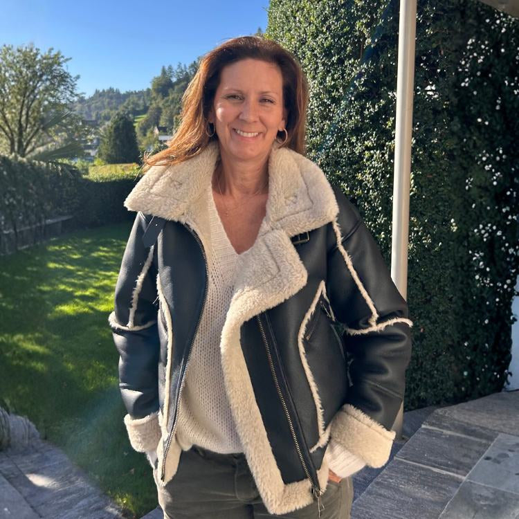 Frau trägt stylische schwarze vegane Lederjacke mit heller Fellinnenseite – Modeinspiration für die Damenmode-Kollektion von vorne